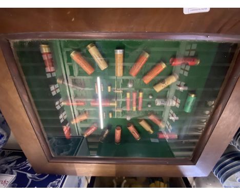 A display case with display of assorted spent gun cartridge shells 54x44cm, shipping unavailable