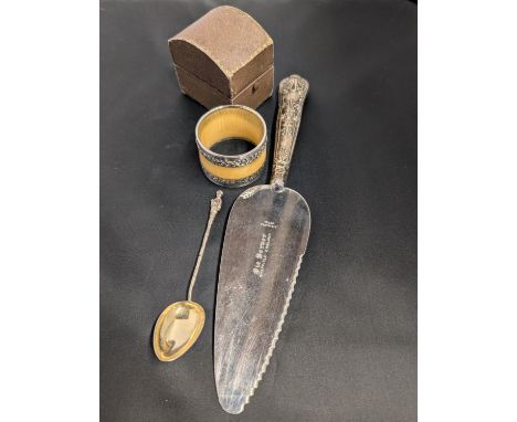 A Chinese silver spoon with a hallmarked silver handled cake knife and a white metal napkin ring