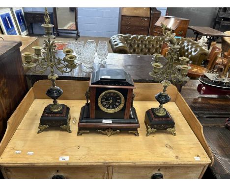 A French black slate and red marble clock garniture, the clock set in an architectural case with metal mounts together with a