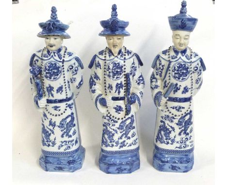 A group of three 20th Century Chinese dignitaries or officials holding various implements including a Ruyi, a fan and a scrol