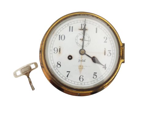 A maritime brass bulkhead clock. Roland Morris collection, with Sestrel movement, Capt O.M Watts Ltd London, diameter 17cm.  