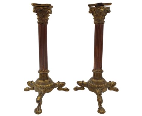 A pair of late 19th century copper and brass candlesticks raised on tripod lion paw supports, height 29cm.