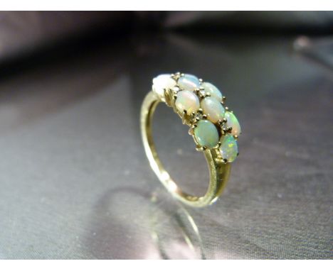 9ct Gold Opal and Diamond Ring. 10 oval opals interspersed with 7 small diamonds in an approx 7.8mm wide setting. These make 