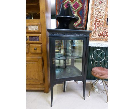 Black lacquered corner cabinet with mirrored back to shelves, over sits a singular corner shelf flanked by carved finials