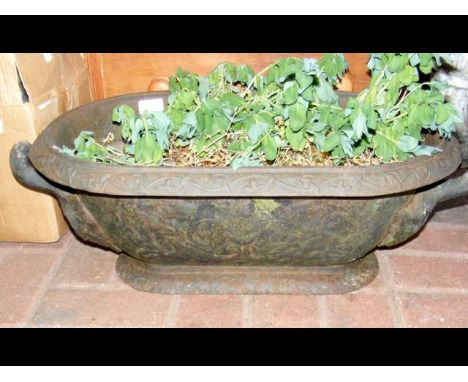 A decorative cast metal garden trough 
