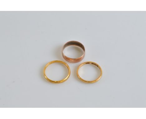 Three wedding bands, comprising two 22ct gold 6g, ring size M and K, together with a 9ct gold example 1.6g size K (3)