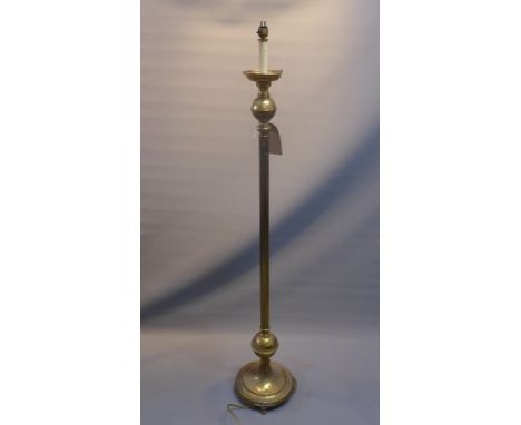 An early 20th century brass standing lamp with reeded column raised on circular base and bun feet 