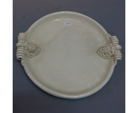 A Victorian ceramic meat platter having twin handles in the form of lions with impress stamp to base with a griffin and indis