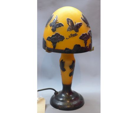 A Galle style table lamp, with yellow glass lamp and stem having butterfly and flower design, H. 36cm