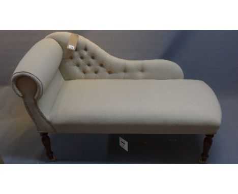 A chaise longue having stone linen button back upholstery, with cushion, raised on turned legs and castors, L. 118cm 