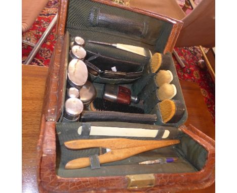 A 20th century crocodile skin gentleman's travelling vanity case, with fully fitted interior, including brushes, hip flask, c