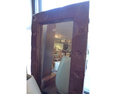 A large 20th Century mirror with brown leather button down upholstery, 187cm x 72cm