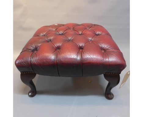 A 20th Century mahogany foot stool with red leather button down upholstery