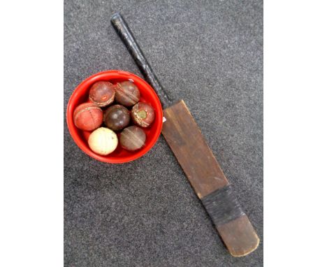 A vintage wooden cricket bat together with a box containing seven vintage cricket balls   