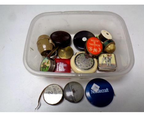 A box containing vintage 20th century haberdashery tape measures, some bearing advertisement  