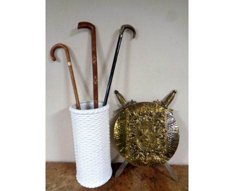 Two pottery jugs and a ceramics stick stand containing sticks (one with silver mount), ornate brass embossed shield with two 