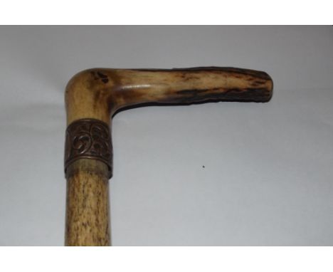 Whale bone walking stick, 19th century of cylindrical tapering form and with antler handle 93cm