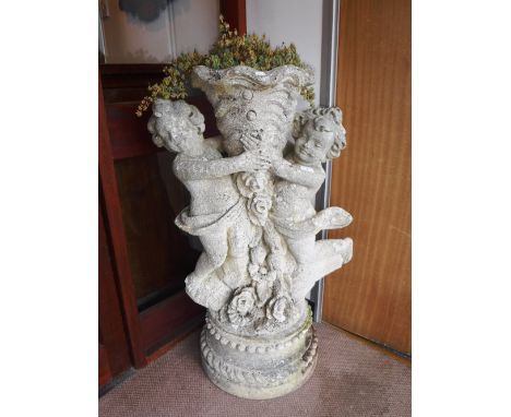 A LARGE RECONSTITUTED STONE STATUE of two cherubs, formed as a cornucopia planter, 39.5" high