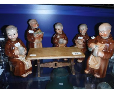 A COLLECTION OF WEST GERMAN CERAMIC FLASKS IN THE FORM OF MONKS, around a trestle table