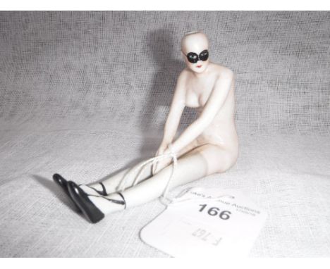 A CERAMIC FIGURE OF A LADY wearing shoes, stockings, and an eye-mask