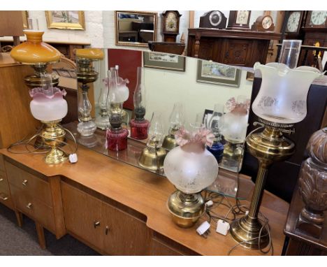 Collection of oil lamps including Cranberry glass, etched shades, brass columned, blue glass hand held oil lamp, etc.