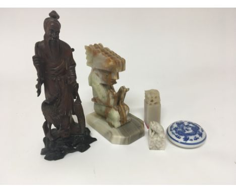 A carved hardwood Chinese figure of an elder seals and a 20th century Chinese red seal wax dish and cover and an onyx figure.