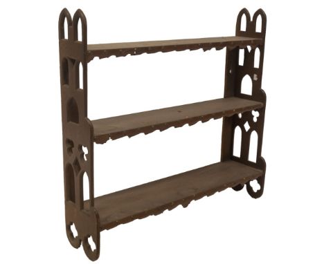 A Victorian gothic oak waterfall wall shelves, with fret work sides, and studded leather shelf fronts, 75cm H, 77cm W, 20cm D