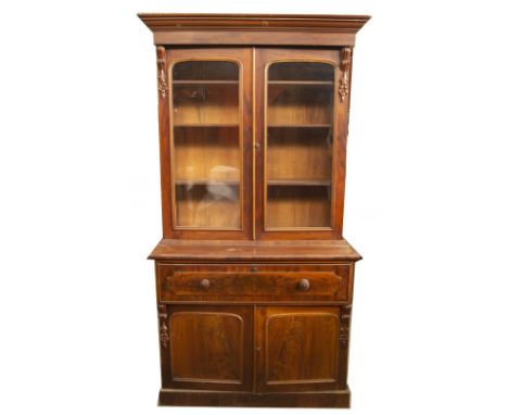 An early Victorian mahogany secretaire cabinet bookcase, with moulded cornice, scroll and floral carved support doors, with a