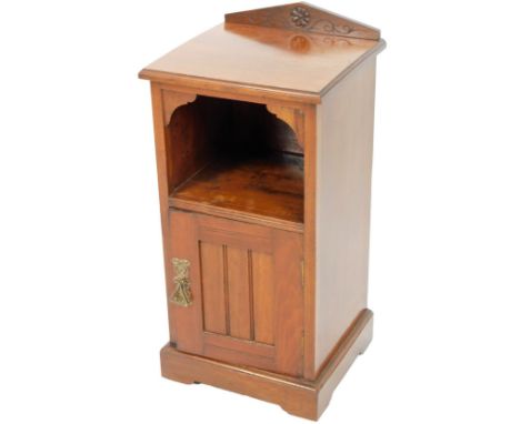 An Edwardian oak pot cupboard, the fixed pedimented top, centred by a floral patera, above an open shelf and cupboard beneath