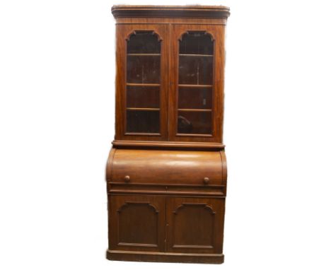 A Victorian mahogany cabinet cylinder bureau bookcase, with moulded cornice and two rounded and glazed doors revealing shelve