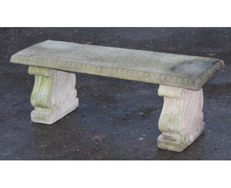 A 20thC carved stone garden bench, the rectangular top raised on double scroll feet, 43cm H, 114cm W, 40cm D.