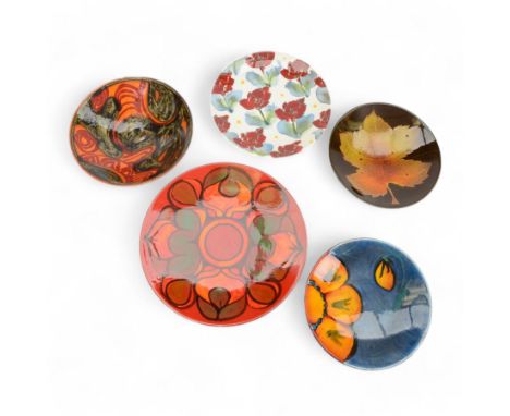 Three Poole pottery chargers, in Wild Poppy pattern, Delphis pattern and Aegean pattern, together with a Poole pottery dish a