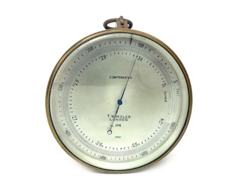 BRASS CASED ANEROID BAROMETER BY T. WHEELER, No. 3382, with engraved circular silverised dial, 12cm diameter