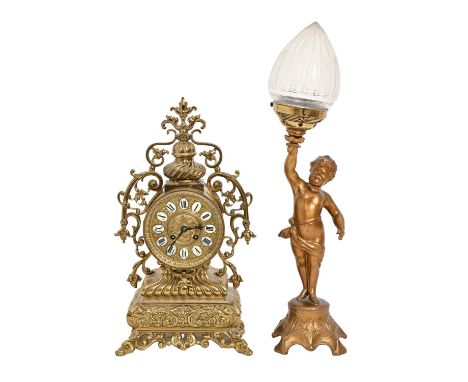 An ornate pierced brass mantel clock, in 18th c French style, the dial with enamel chapters, 43cm h and a gilded metal standa
