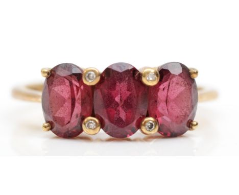 A 9ct gold three stone garnet dress ring, O, 2.5gm. 