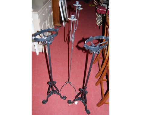 A pair of early 20th century black painted wrought iron paraffin lamp stands (lacking fittings); together with a branch arm c