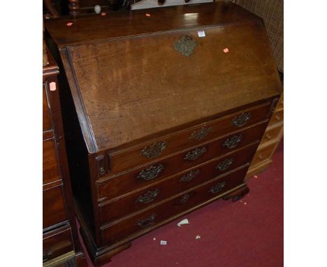 A George III mahogany slopefront writing bureau, having a fitted interior, over four long graduated drawers to ogee bracket s