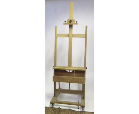 An artist large wooden folding easel, the rectangular frame raised on a square base mounted with casters, 163cm unextended. (