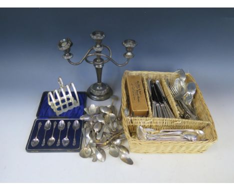 A collection of plated flatwares, various patterns, a plated twin branch candelabra, cased tea spoons and a four division toa