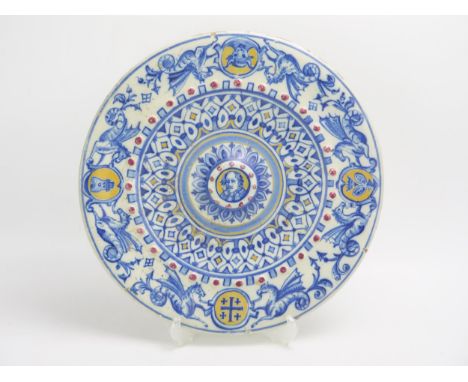 A Spanish tin glaze charger, the central boss with portrait decoration, enclosed by a hippocanthus border, 41cm diameter.