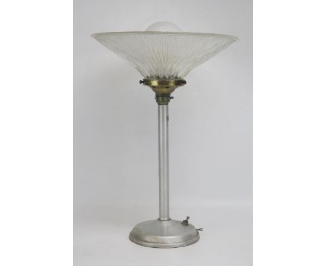 An Art Deco period Holophane aluminium table lamp, with clear glass flared shade, on a weighted circular base. overall height