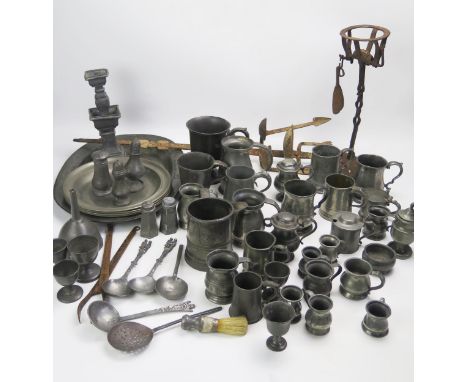 A large collection of assorted pewter wares, includes plates mugs condiments, spoons, candlestick, rush light holder and othe