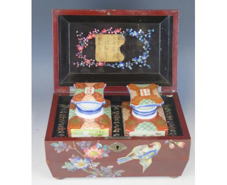 A 20th century Chinese lacquered and mother-of-pearl inlaid tea caddy, of rectangular outline containing two porcelain tea ca