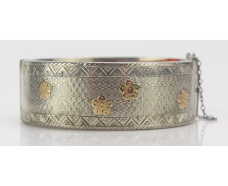 A Victorian Style Silver Hinged Bangle with gilt flower head decoration, hallmarked, 31.07g