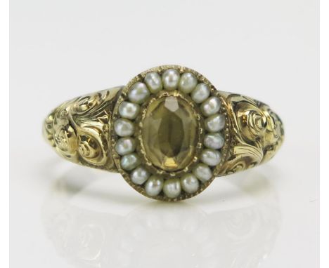 A Georgian Split Pearl and Foil Backed Gem Set Ring in a high carat precious yellow metal setting with chased scroll work to 