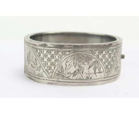 A Victorian Silver Hinged Bangle with chased foliate and bird decoration, Birmingham 1876, 31.7g