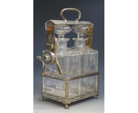 A plated tantalus containing two etched glass decanters and stoppers, the frame with loop carrying handle,  raised on pad fee