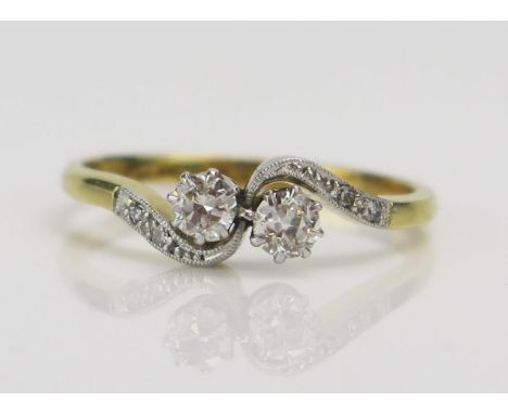 An 18ct Gold and Brilliant Cut Diamond platinum Set Crossover Ring, c. 3.5-3.35mm stones, size M.5, stamped 18CT PLAT, 2.39G