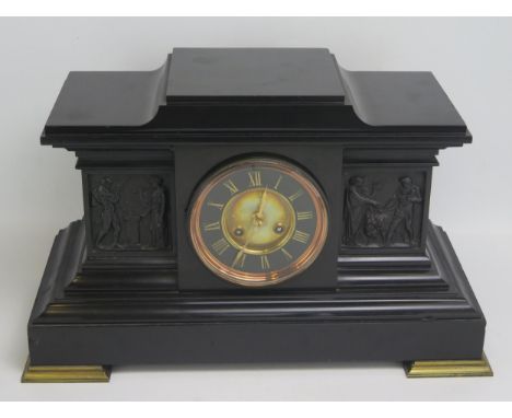 A polished slate mantel clock of architectural form, with 12cm Roman dial flanked by neo-classical friezes, now fitted with a
