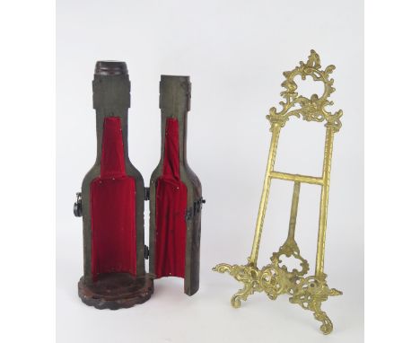 A cast brass easel stand, with foliate crest, 51cm high together with a wood bottle holder, (2)